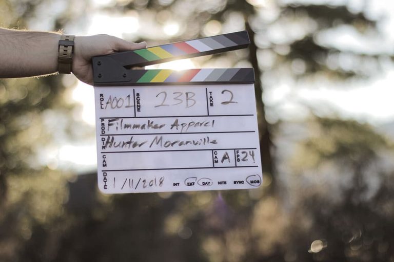 2nd AC holding clapperboard on film set