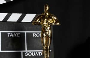 Gold Academy Award Trophy and clapperboard on a black background