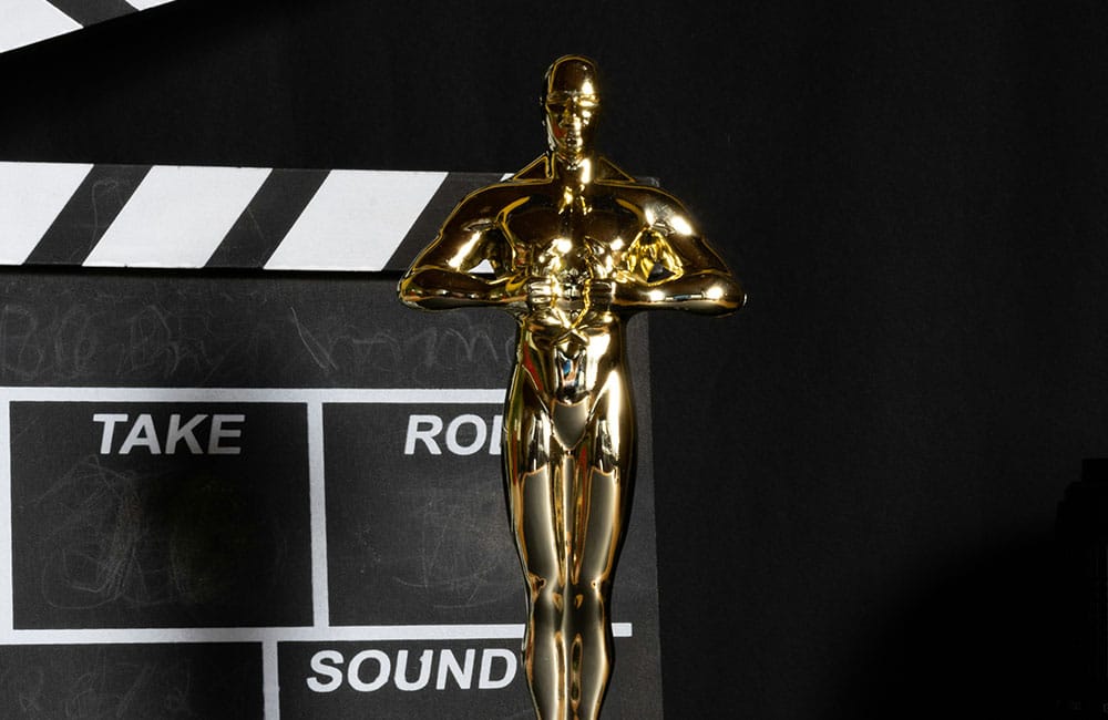 Gold Academy Award Trophy and clapperboard on a black background