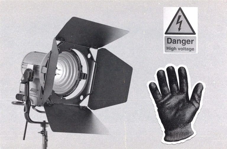 studio light next to a high-voltage warning sign, and protective glove.