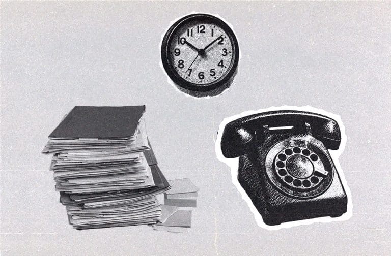Stack of production paperwork next to a wall clock and a vintage rotary telephone.